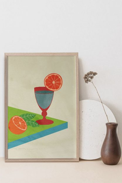An art print poster of a cocktail glass and slice of orange