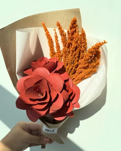 A mini flower bouquet with a fossilized flower and 3 red wooden roses.