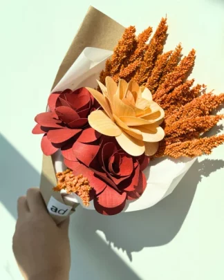 A flower bouquet with an orange fossilized flower and 3 colored wooden roses.