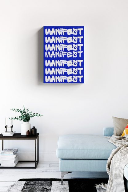 Manifest Typography Canvas in the white room with white wall, the sofa is blue and the coffee table is made of wood