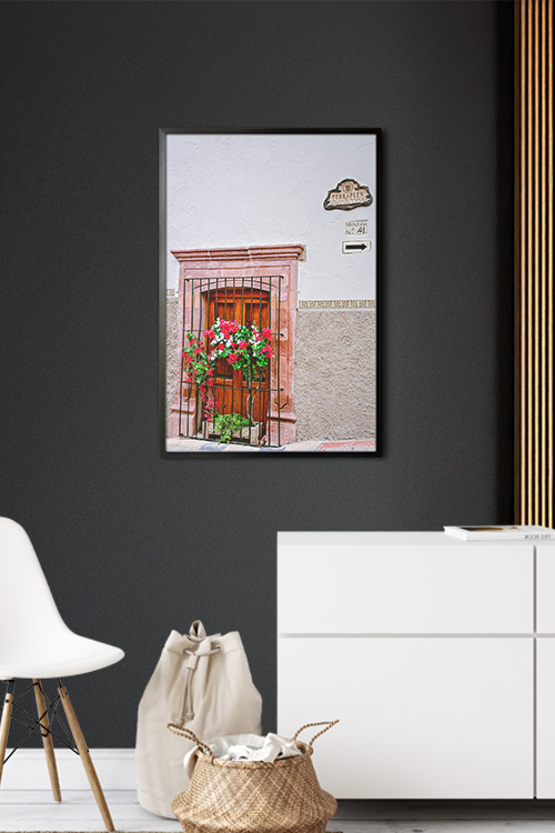 Entry in Bloom poster print in a black frame hanged on a dark walled living room